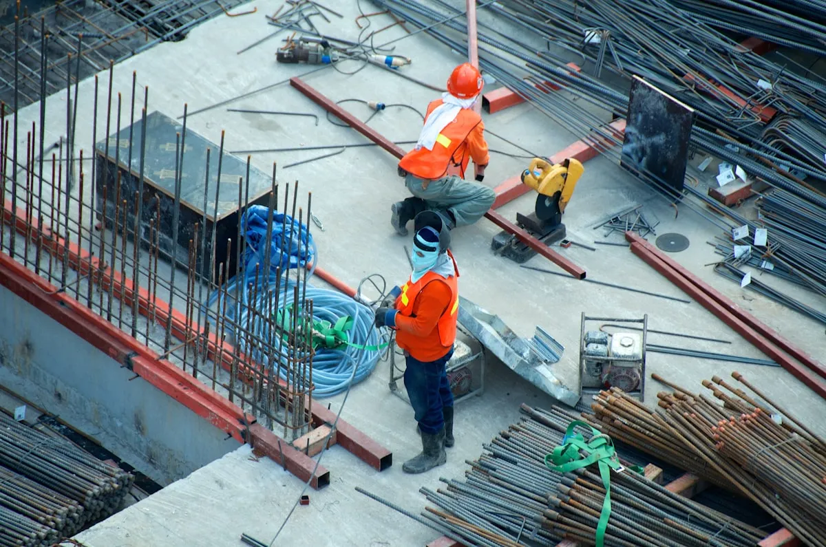 Construction workers on an active job site with steel reinforcement