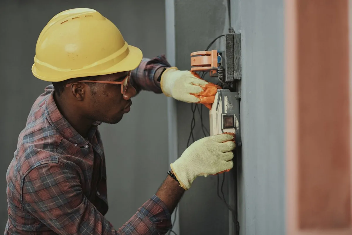 Electrician in safety gear working on a residential electrical panel