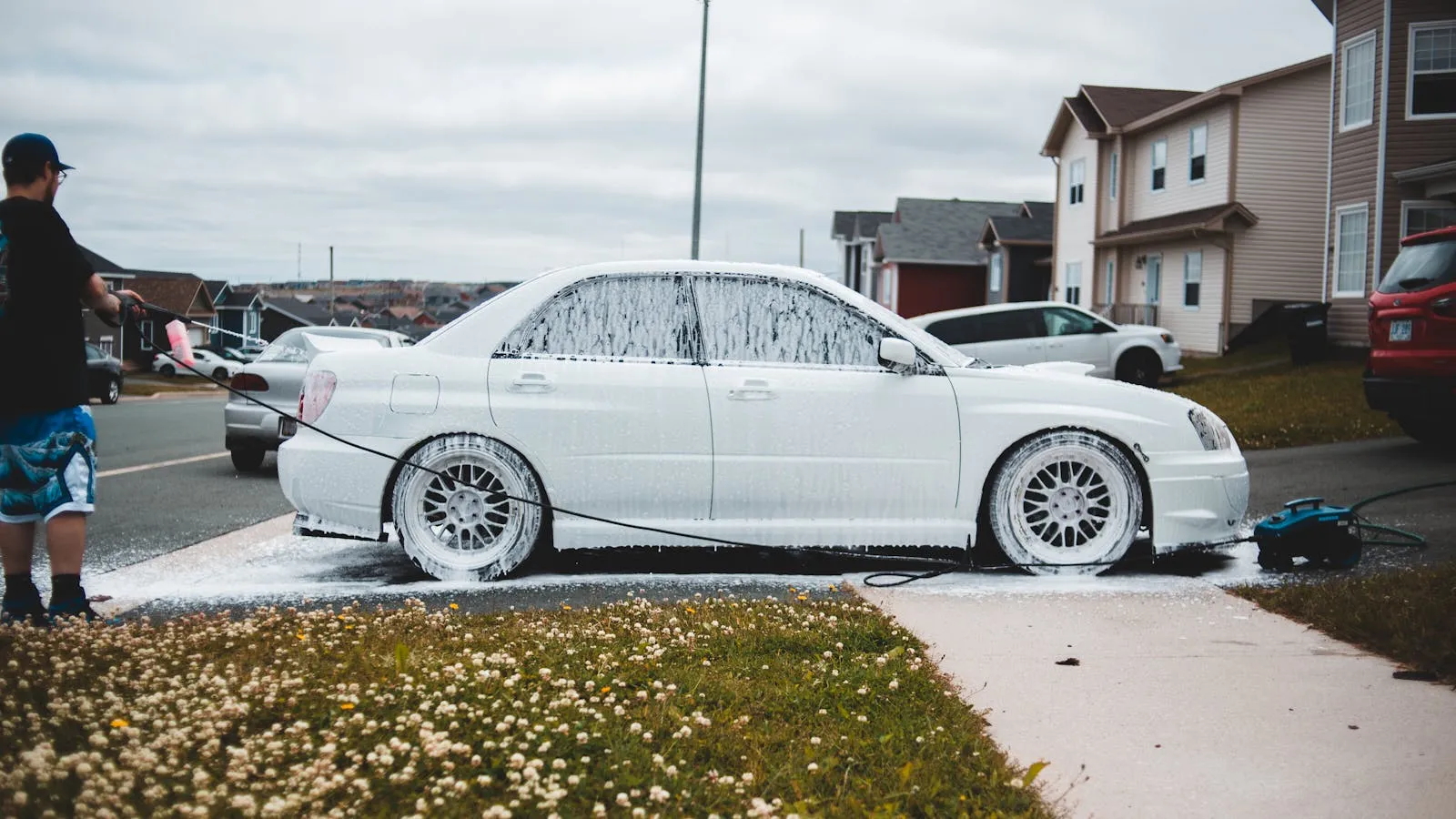 Pressure washer cleaning a vehicle with high-pressure water and foam