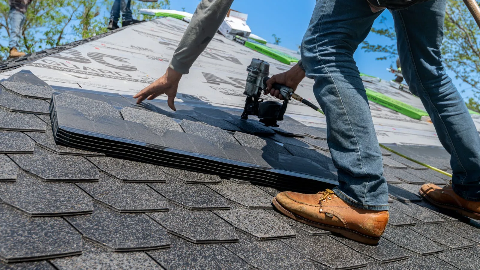 Professional roofer installing shingles on a residential roof